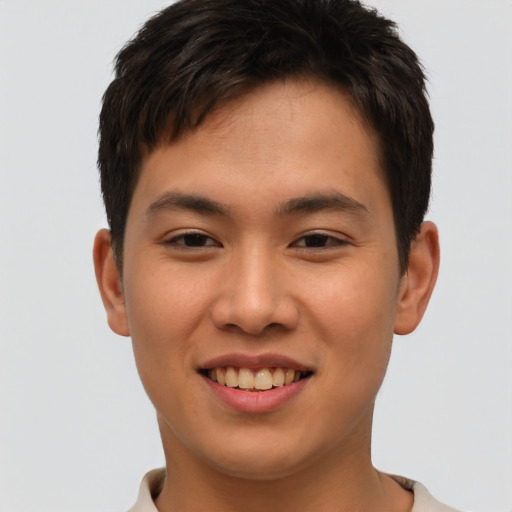 Joyful asian young-adult male with short  brown hair and brown eyes