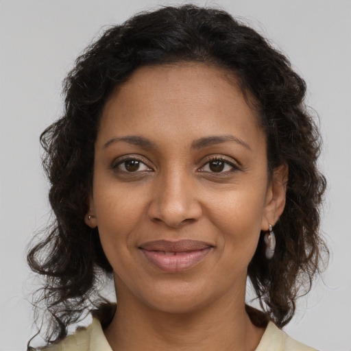 Joyful black young-adult female with medium  brown hair and brown eyes