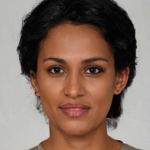 Joyful black young-adult female with medium  black hair and brown eyes