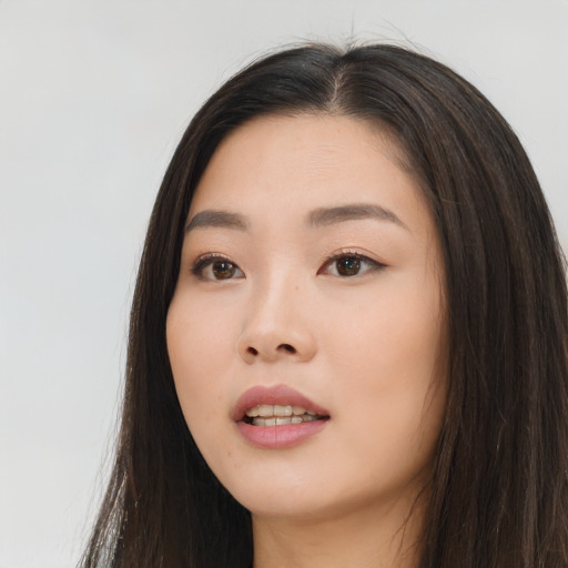 Joyful asian young-adult female with long  brown hair and brown eyes