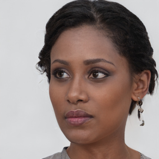 Neutral black young-adult female with medium  brown hair and brown eyes