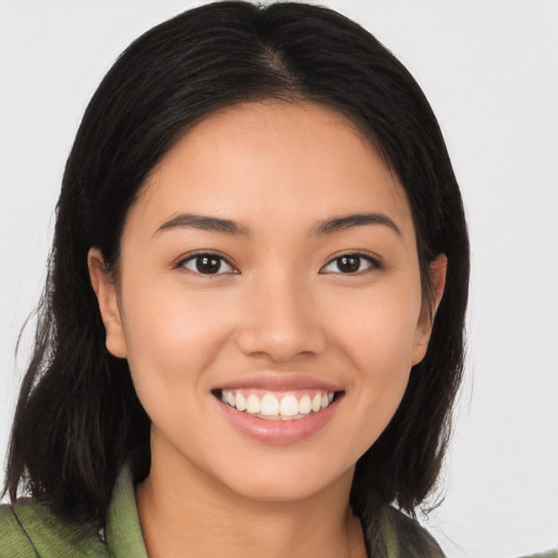 Joyful latino young-adult female with long  brown hair and brown eyes