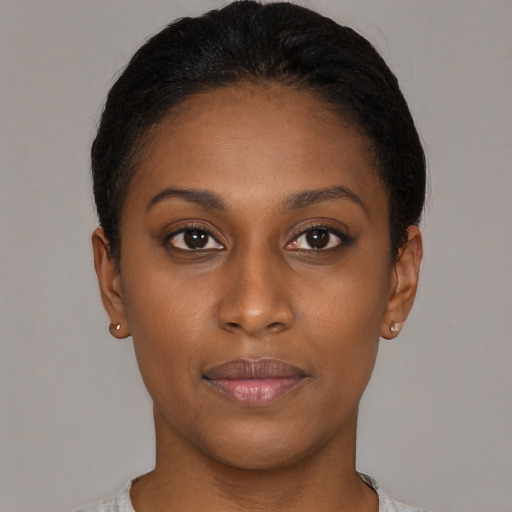 Joyful black young-adult female with short  black hair and brown eyes