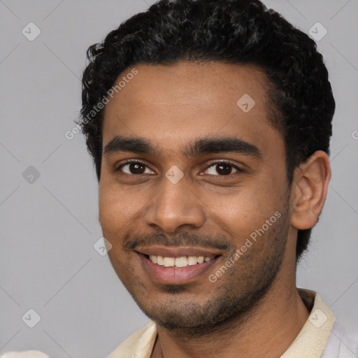 Joyful black young-adult male with short  black hair and brown eyes