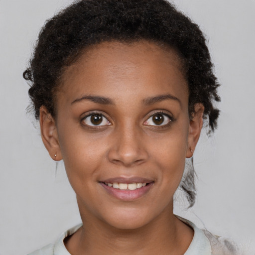 Joyful black young-adult female with short  brown hair and brown eyes