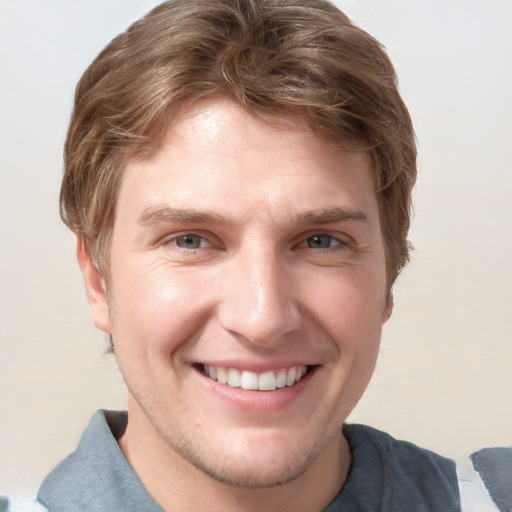 Joyful white young-adult male with short  brown hair and blue eyes