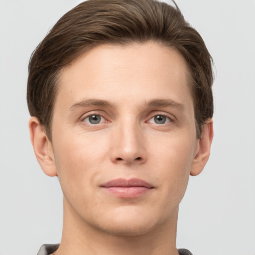 Joyful white young-adult male with short  brown hair and grey eyes