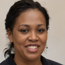 Joyful black adult female with medium  brown hair and brown eyes