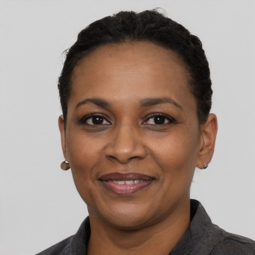 Joyful black adult female with short  black hair and brown eyes