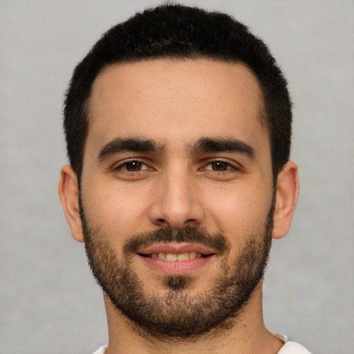 Joyful white young-adult male with short  black hair and brown eyes