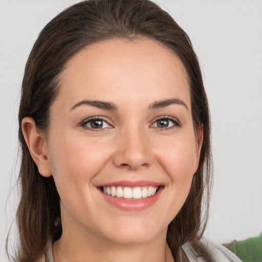 Joyful white young-adult female with medium  brown hair and grey eyes