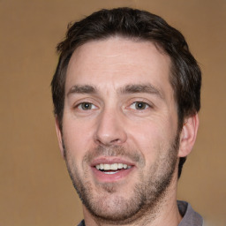 Joyful white adult male with short  brown hair and brown eyes