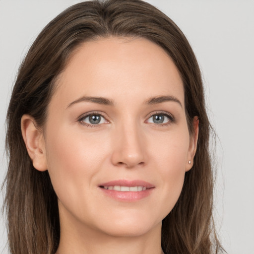 Joyful white young-adult female with long  brown hair and grey eyes