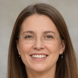 Joyful white adult female with long  brown hair and grey eyes