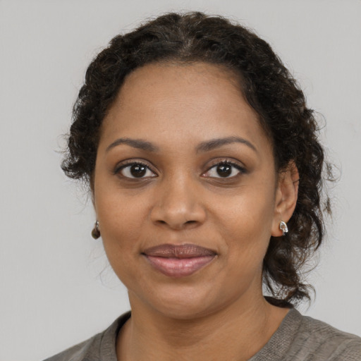 Joyful black young-adult female with medium  brown hair and brown eyes