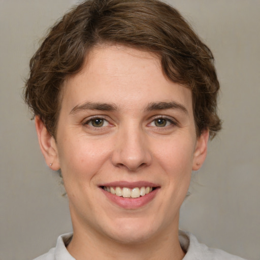 Joyful white young-adult female with short  brown hair and green eyes