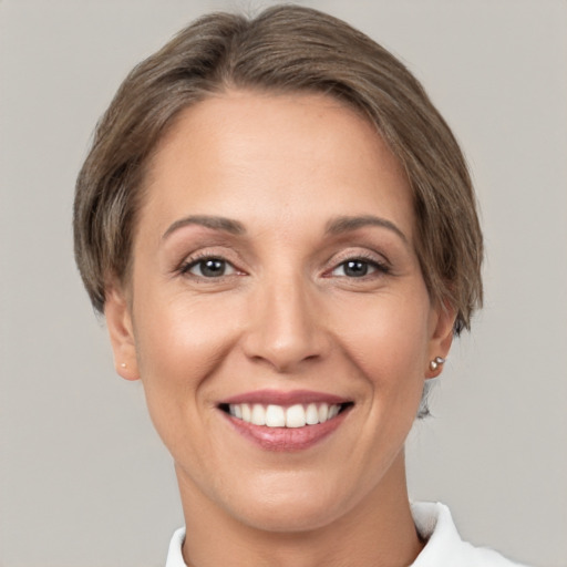 Joyful white adult female with short  brown hair and grey eyes