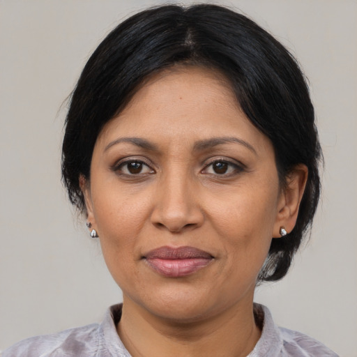 Joyful latino adult female with medium  black hair and brown eyes