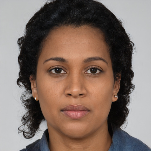 Joyful black young-adult female with long  black hair and brown eyes