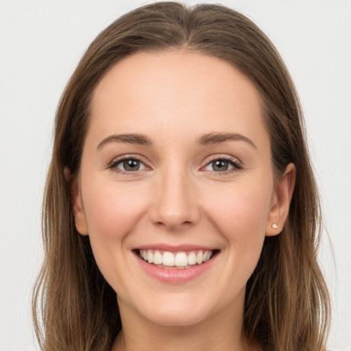 Joyful white young-adult female with long  brown hair and green eyes