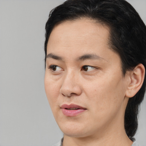 Joyful white adult female with medium  black hair and brown eyes