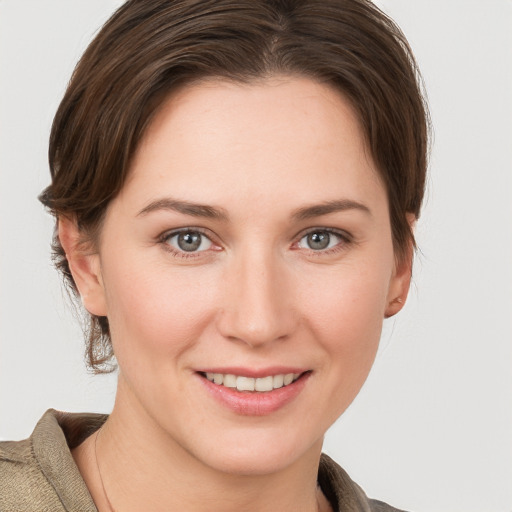 Joyful white young-adult female with short  brown hair and grey eyes