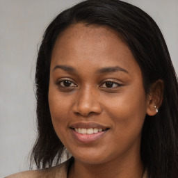 Joyful black young-adult female with long  brown hair and brown eyes