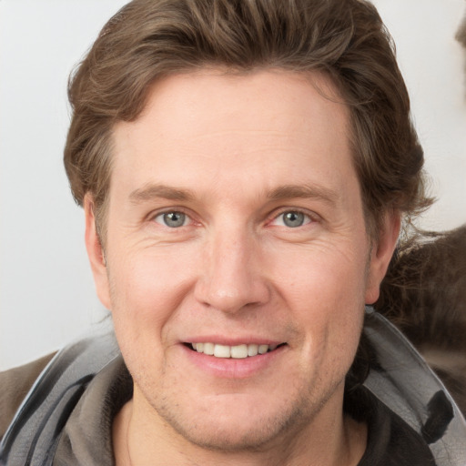 Joyful white adult male with short  brown hair and grey eyes