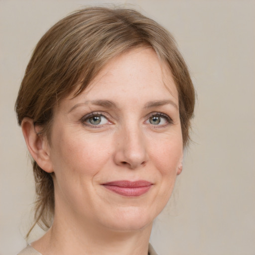 Joyful white adult female with medium  brown hair and grey eyes