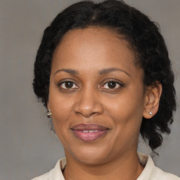 Joyful black adult female with medium  brown hair and brown eyes