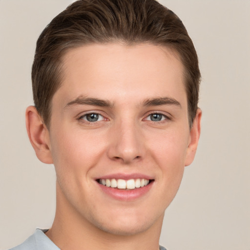 Joyful white young-adult male with short  brown hair and grey eyes