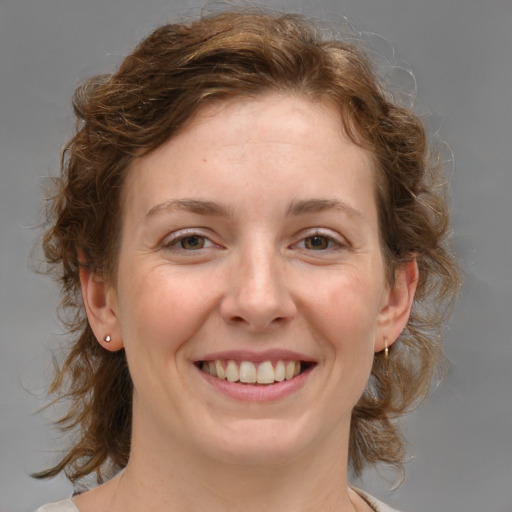 Joyful white young-adult female with medium  brown hair and blue eyes