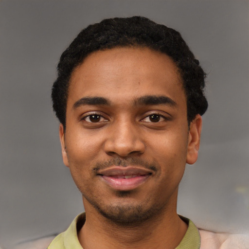 Joyful black young-adult male with short  black hair and brown eyes