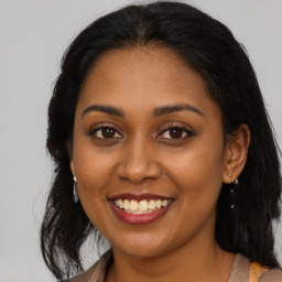 Joyful black young-adult female with medium  brown hair and brown eyes