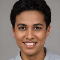 Joyful latino young-adult male with short  black hair and brown eyes