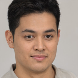 Joyful latino young-adult male with short  brown hair and brown eyes