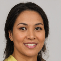 Joyful latino young-adult female with medium  brown hair and brown eyes