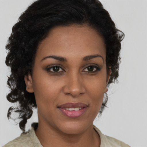 Joyful black young-adult female with long  brown hair and brown eyes