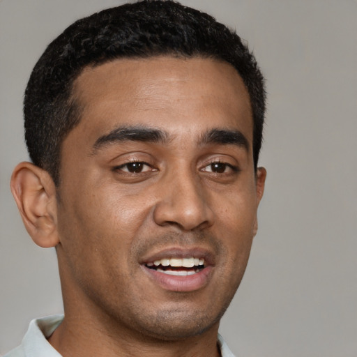 Joyful black young-adult male with short  brown hair and brown eyes