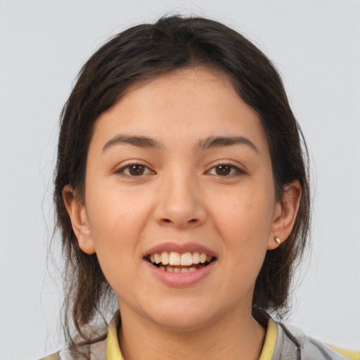 Joyful latino young-adult female with medium  brown hair and brown eyes