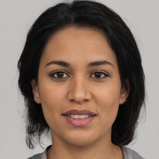 Joyful latino young-adult female with medium  brown hair and brown eyes