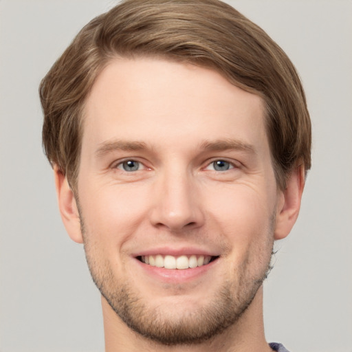 Joyful white young-adult male with short  brown hair and grey eyes