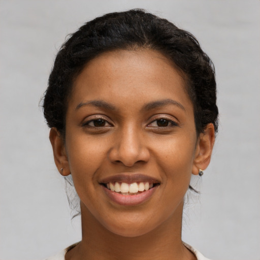 Joyful latino young-adult female with short  brown hair and brown eyes