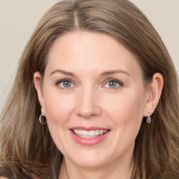 Joyful white adult female with long  brown hair and grey eyes