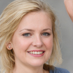 Joyful white young-adult female with medium  brown hair and blue eyes