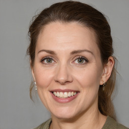 Joyful white adult female with medium  brown hair and green eyes