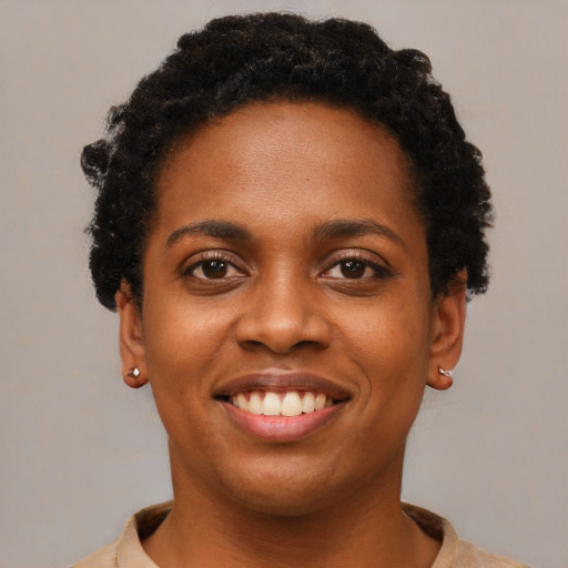 Joyful black young-adult female with short  black hair and brown eyes