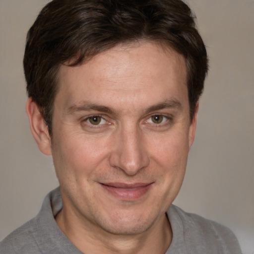 Joyful white adult male with short  brown hair and grey eyes