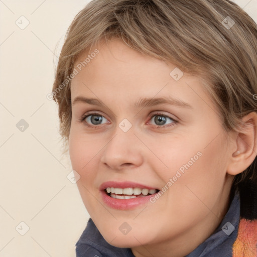 Joyful white young-adult female with medium  brown hair and blue eyes