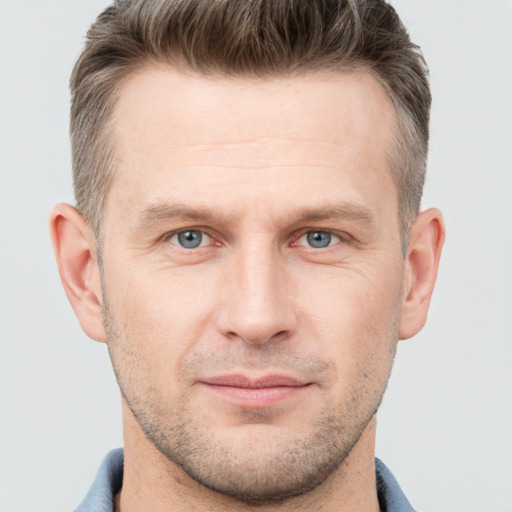 Joyful white adult male with short  brown hair and grey eyes